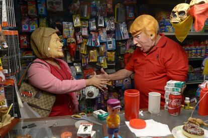 Dos visitantes con máscaras de los candidatos presidenciales Donald Trump y Hillary Clinton bromean el 13 de octubre de 2016, en la Casa de los Trucos, en Miami, Florida (EE.UU.). 