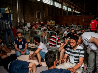 Los supervivientes del naufragio del 'Adriana', en el mar Jónico, se sientan en el interior de un almacén en el puerto de la ciudad griega de Kalamata, el 15 de junio.