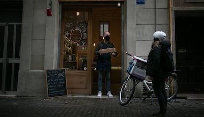 Jordi Arias de la botiga Bebe-te lliura un paquet a una missatgera de Les Mercedes.