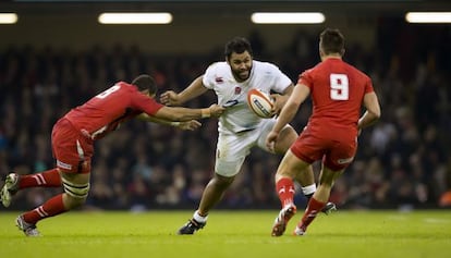 Billy Vunipola intenta esquivar a los galeses Taulupe Faletau y Rhys Webb.