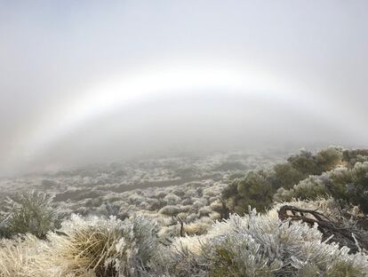 Pese al fuerte viento, la niebla también ha hecho acto de presencia, dejando aparecer en el cielo un arcoiris.