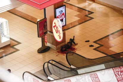 Un cuerpo sin vida yacen en el suelo una vez que la polic&iacute;a ha evacuado el centro comercial.