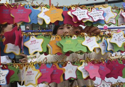 Uma mulher pendura estrelas com desejos para o Ano Novo no lado de fora do templo budista Jogyesa, em Seul, na Coreia do Sul.