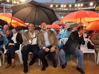 Francisco Camps tuvo que echar mano del paraguas para cubrir a Mariano Rajoy de la lluvia durante el mitin en Valencia.