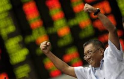 Un accionista filipino gesticula frente a un tablero electrónico de la Bolsa de Filipinas en el distrito financiero de Makati, en Manila. EFE/Archivo