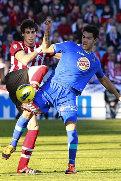 Javi Martínez y Miku pugnan por un balón.