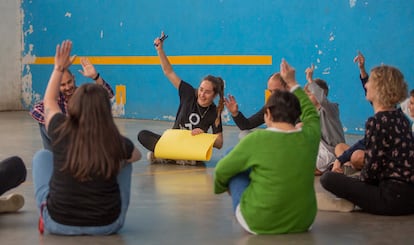 Varios de los participantes levantan la mano en una de las actividades organizadas por la ONG.