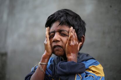 Aryan, un hermano de Siddharth Dhage, se lava la cara antes de ir a la escuela, en el exterior de su casa en Aurangabad (India).