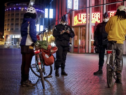 Policías belgas multan a dos ciclistas por violar el toque de queda, este martes en Bruselas.