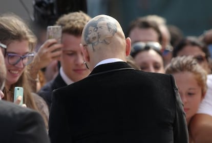 James Franco, de espaldas y rapado, firmando aut&oacute;grafos en el festival de Venecia. 