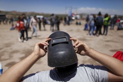 Usando una máscara de soldador como protección, un hombre ve un eclipse total en Piedra del Aguila, Argentina.