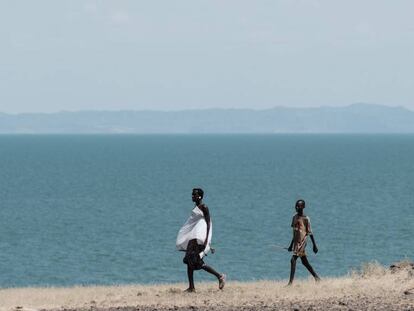 Dos personas caminan junto al lago Turkana, el mayor lago situado en un desierto del mundo, en el norte de Kenia.