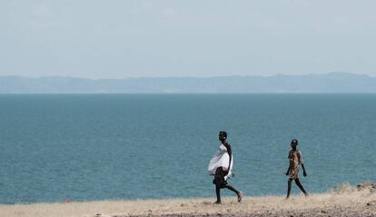 Dos personas caminan junto al lago Turkana, el mayor lago situado en un desierto del mundo, en el norte de Kenia.