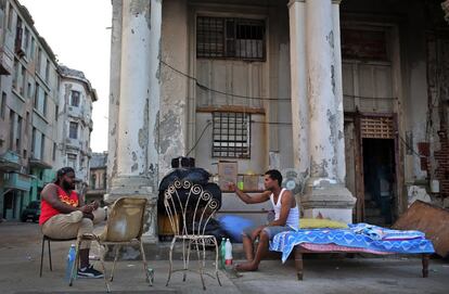 Dos hombres cuya vivienda fue severamente afectada por el huracán Irma conversan junto a sus pertenencias en el malecón de La Habana (Cuba).
