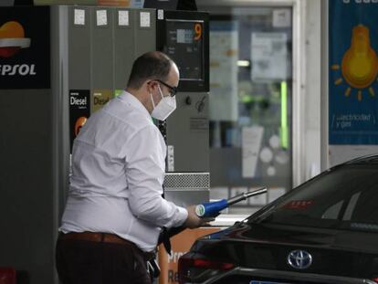 Un hombre echa gasolina a su coche en una gasolinera.