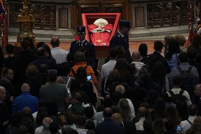 Centenares de fieles contemplan el féretro con los restos mortales del papa Francisco situado en la basílica de San Pedro, este viernes. 