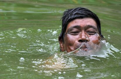 Un hombre participa se baña en un estanque durante una fiesta tradicional nepalí en Khokana, a las afueras de Katmandú. 12 de agosto de 2014.