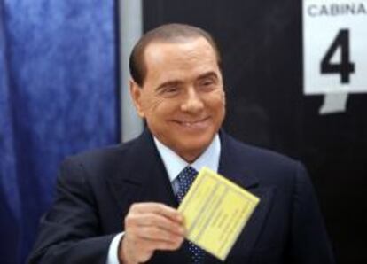 Former Prime Minister Silvio Berlusconi smiles as he casts his vote at the polling station in Milan, February 24, 2013. Italians began voting on Sunday in one of the most closely watched elections in years, with markets nervous about whether it can produce a strong government to pull Italy out of recession and help resolve the euro zone debt crisis. REUTERS/Stefano Rellandini  (ITALY - Tags: POLITICS ELECTIONS) ITALY-VOTE/