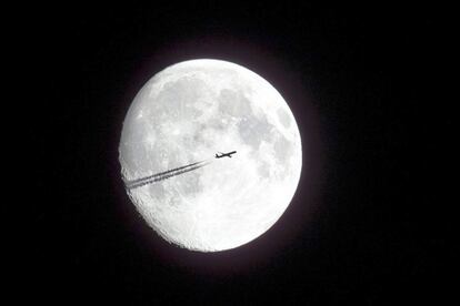 La silueta de un avión en pleno vuelo con la Luna de fondo visto desde Kalchreuth, Alemania. 8 de Agosto de 2014.