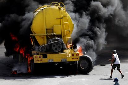 Un manifestante pase junto a un camión quemado durante los enfrentamientos.