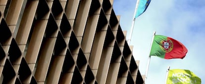 La bandera portuguesa, la europea y la de un banco luso ondean en un edificio. 