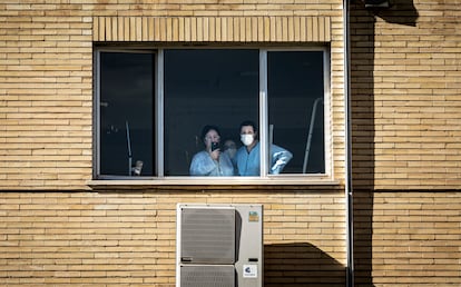 Ana M. M., enferma de covid ingresada en la antigua Fe, ve desde la ventana a su marido e hijos, que la saludan desde la calle.