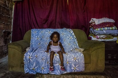 Menina no sofá. Uma das habitantes do edifício abandonado do IBGE. Favela da Mangueira, Rio de Janeiro.