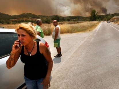 Una mujer habla por teléfono en uno de los frentes del fuego forrestal.