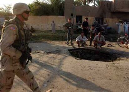 Un soldado estadounidense atraviesa el lugar de la ciudad de Jalis donde explotó el coche bomba.