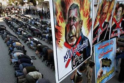 Militantes de Yihad Islámica rezan detrás de carteles contra Bush, el primer ministro interino de Israel, Ehud Olmert, y Rasmussen.