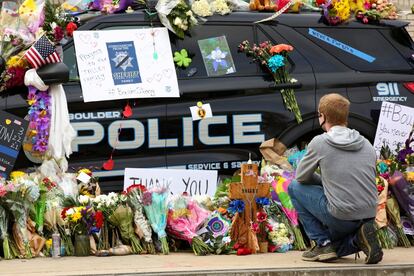 La gente deposita flores en el coche de policía del oficial Eric Talley, quien murió durante el tiroteo.
