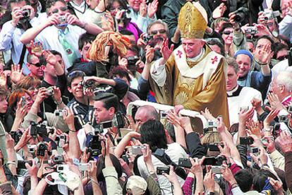 Benedicto XVI saluda desde un vehículo descubierto a los miles de fieles congregados ayer en la plaza de San Pedro tras su misa de coronación como Papa

.