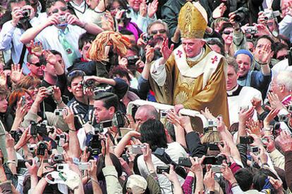Benedicto XVI saluda desde un vehículo descubierto a los miles de fieles congregados ayer en la plaza de San Pedro tras su misa de coronación como Papa
.