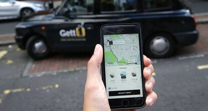 Un usuario de Uber consulta la aplición móvil en Londres