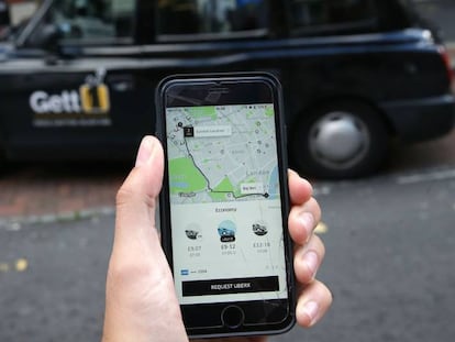 Un usuario de Uber consulta la aplici&oacute;n m&oacute;vil en Londres