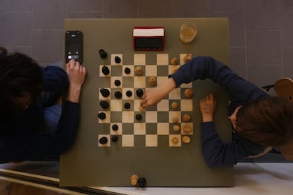 A couple plays chess in a Berlin bar.