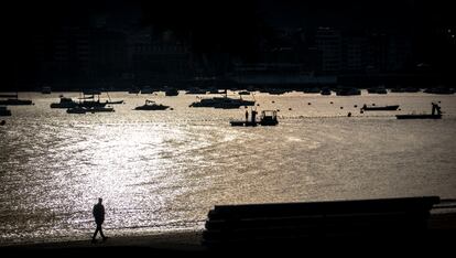 Un hombre paseo a primera hora por la playa de Ondarreta de San Sebastián.