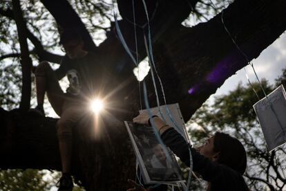 Integrantes del colectivo 'Luciernagas' y activistas participan en la colocación de fotografías de personas desaparecidas, este viernes, en Ciudad de México. 