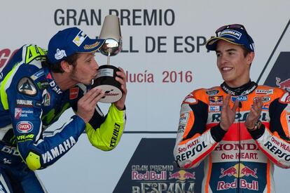 Valentino Rossi besa el trofeo del ganador ante la mirada y los aplausos de Marc Márquez. 