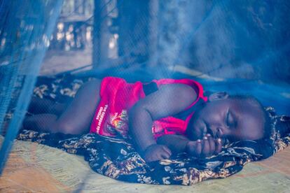 Un bebé nacido en Dadaab duerme sobre el suelo de su casa, protegido por una mosquitera.