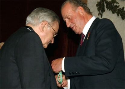 Don Juan Carlos impone al ex gobernador del Banco de España nuevo académico la medalla que le acredita como nuevo académico.