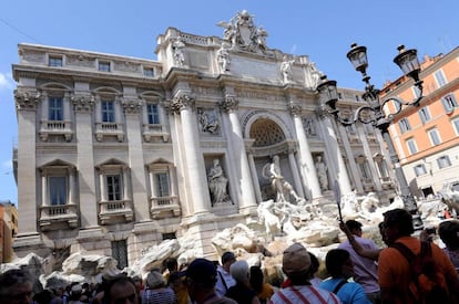 Varios turistas visitan la Fontana de Trevi en Roma.