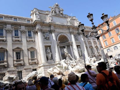 Varios turistas visitan la Fontana de Trevi en Roma.