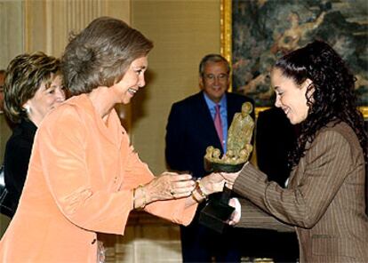 La reina entrega a una joven maestra el simbólico galardón dirigido a todos los profesores.