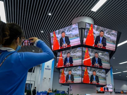 Una mujer graba el discurso de Xi Jinping durante la inauguración de una feria comercial, el pasado jueves en Shanghái.