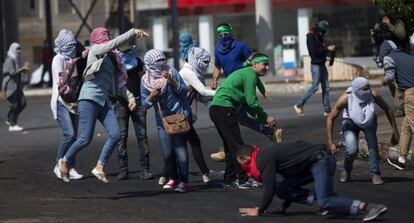 Jóvenes palestinos tiran piedras a soldados israelíes a las afueras de Ramala.