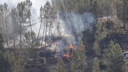 LOS PEIRÓS (TERUEL), 26/03/2023.- Varios bomberos trabajan en la extinción de uno de los focos del incendio forestal que afecta a las provincias de Castellón y Teruel, este domingo cerca de la aldea de Los Peirós, en Teruel. EFE/ Manuel Bruque