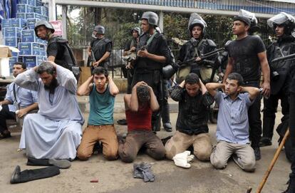 Varios miembros de las fuerzas de seguridad egipcias vigilan a un grupo de manifestantes, en El Cairo en agosto de 2013.