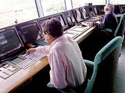 Dos controladores de Barajas supervisan el vuelo de aviones desde los monitores.