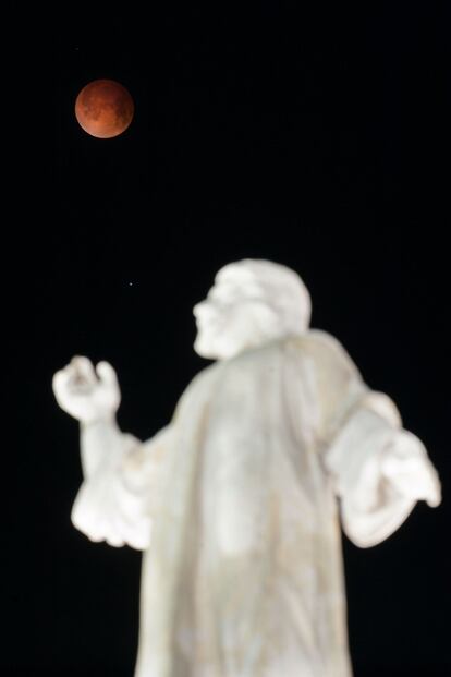 La luna rojiza sobre el monumento de El Salvador del Mundo en San Salvador, El Salvador. 